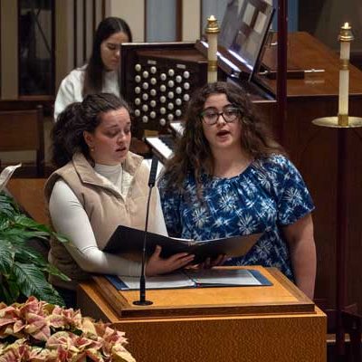 Two women singing at a lectern during Mass